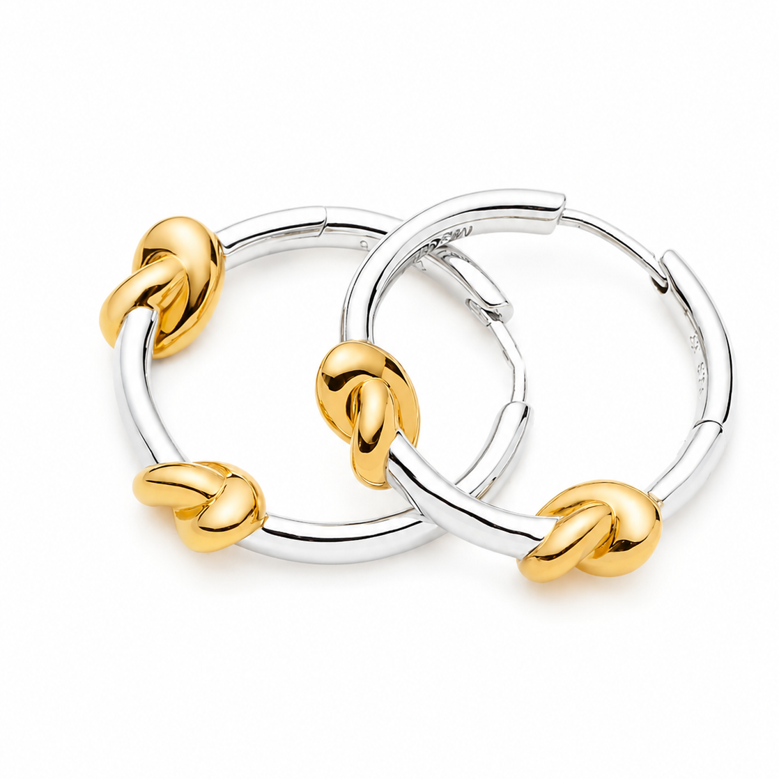 A pair of silver hoop earrings with four gold knotted accent details, displayed on a clean white background.